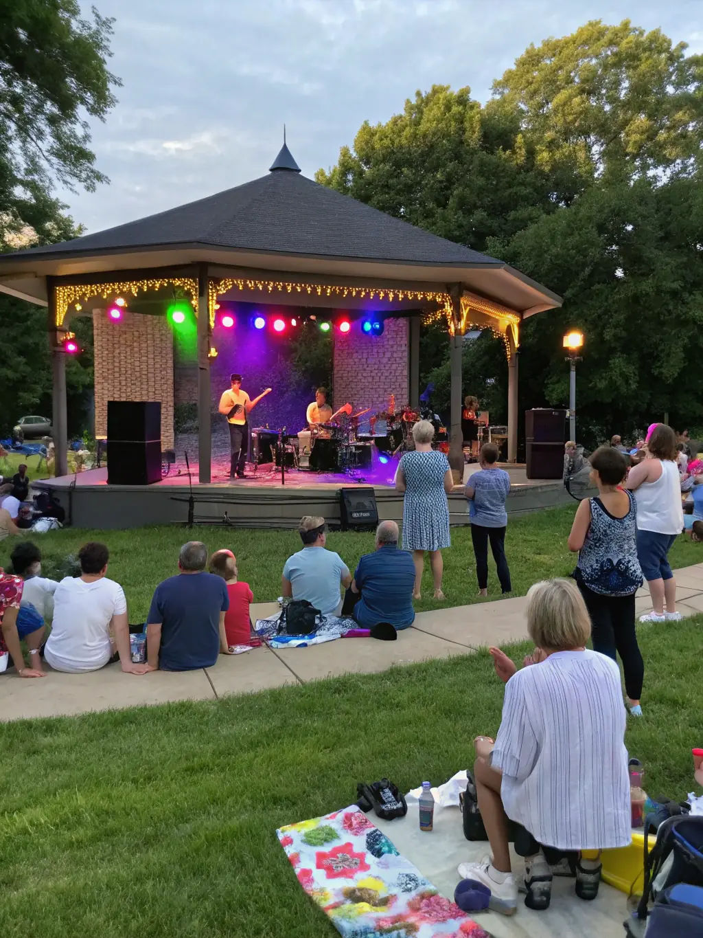 A photograph of local musicians performing live at an outdoor concert organized by COMITÉ DES FÊTES DE CROUZIT HAUT, attracting a diverse audience and promoting local talent.